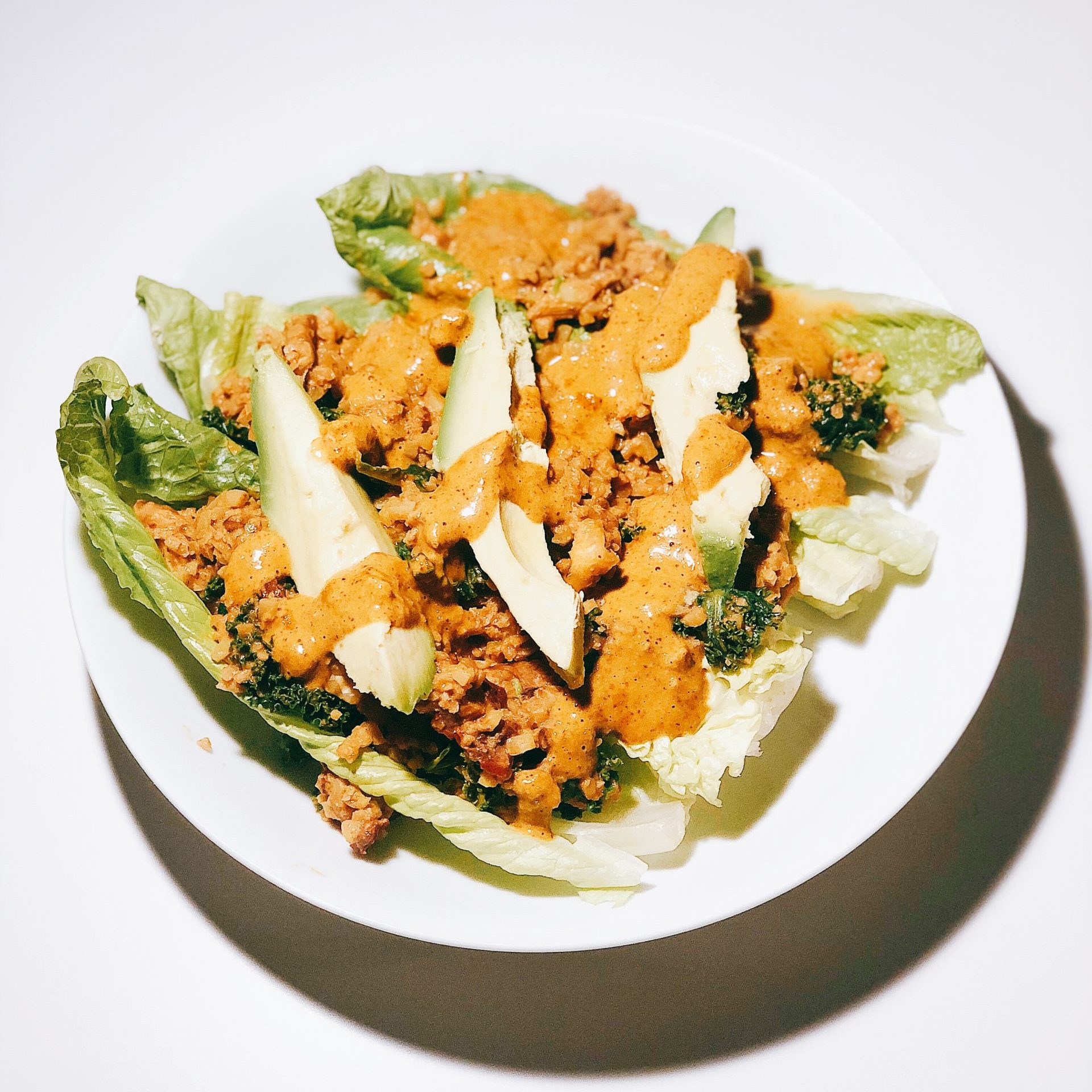 20-minute cauliflower walnut meat with cashew queso on a white plate. Ingredients are in a lettuce boat.